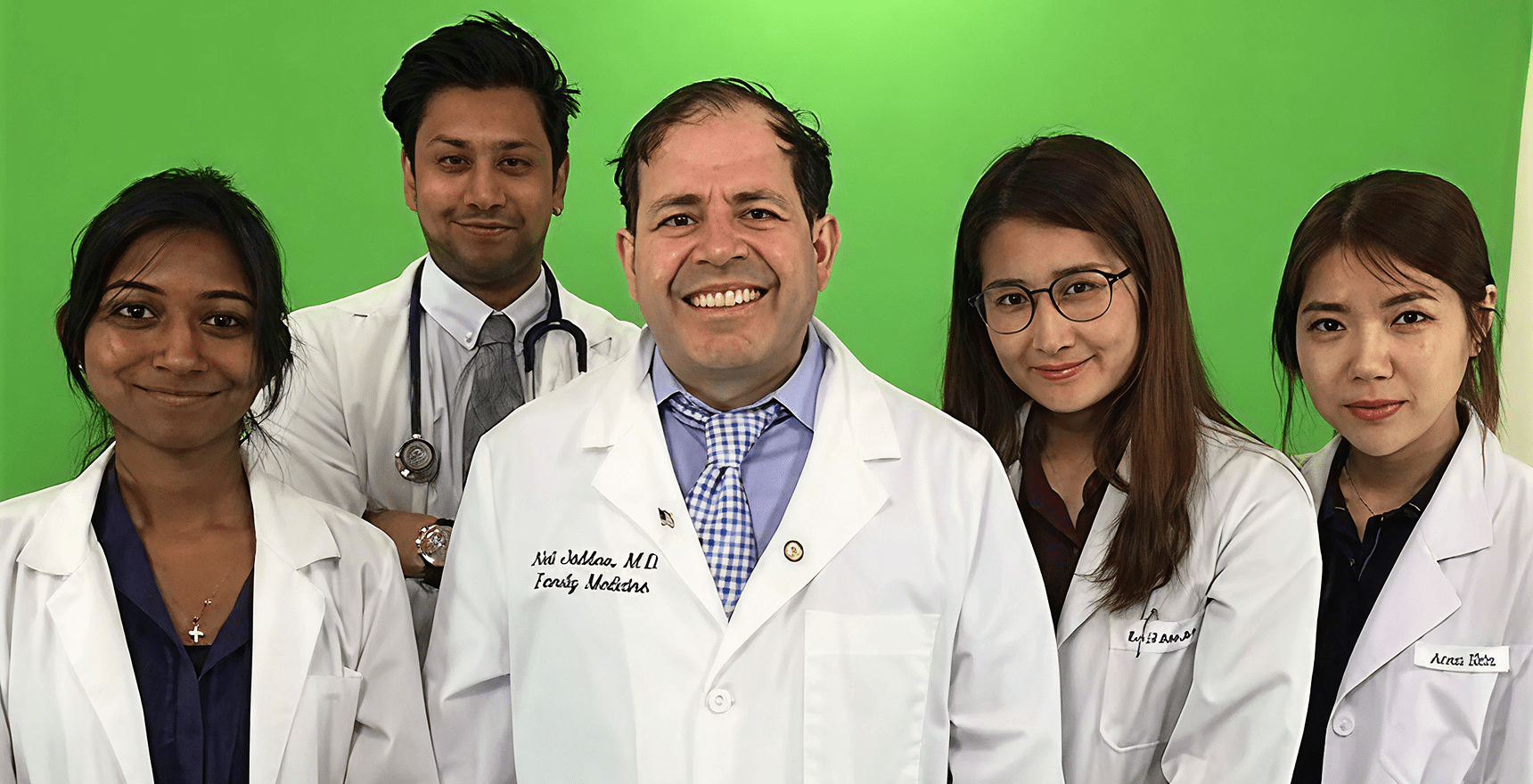 Doctors posing in front of green background
